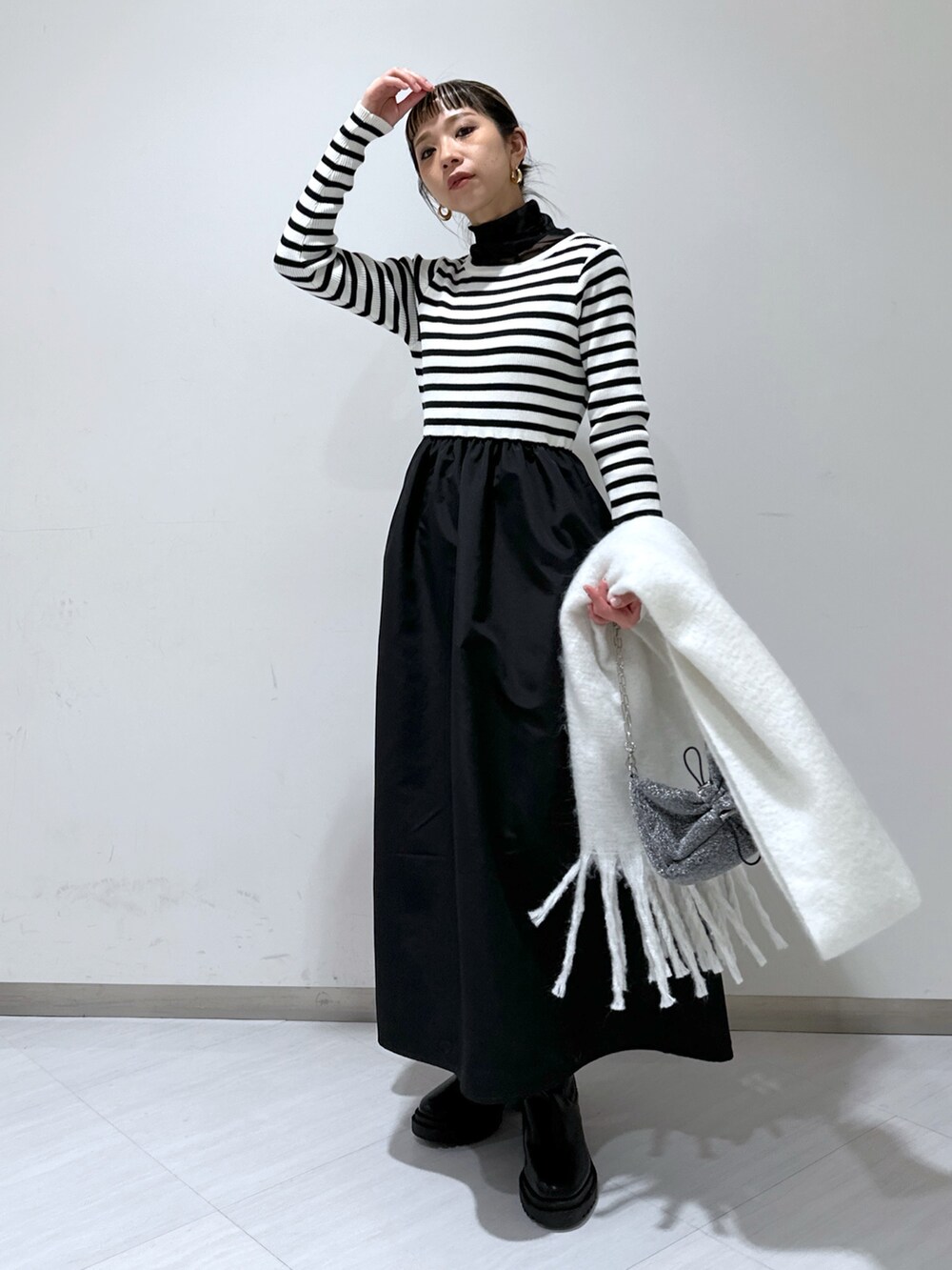 ブラック系のステンカラーコート、ブラック系のワンピース、ブラック系のTシャツ/カットソーを着用したレディースの冬コーディネートの4枚目の写真