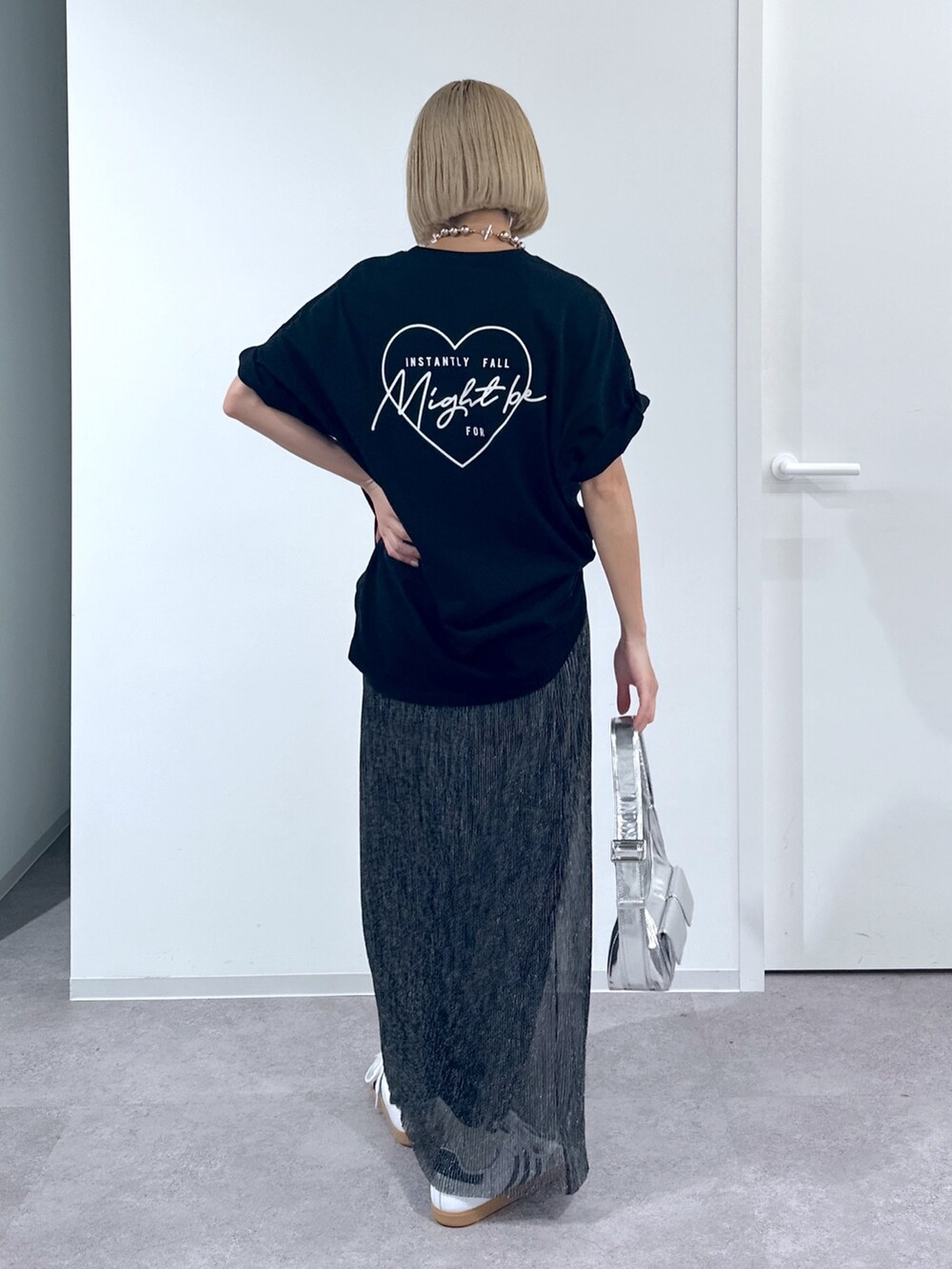 ブラック系のTシャツ/カットソー、ブラック系のスカート、シルバー系のショルダーバッグを着用したレディースの春コーディネートの3枚目の写真