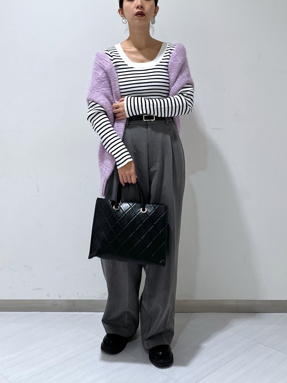 パープル系のニット/セーター、グレー系のスラックス、ホワイト系のニット/セーターを着用したレディースの秋コーディネートの4枚目の写真