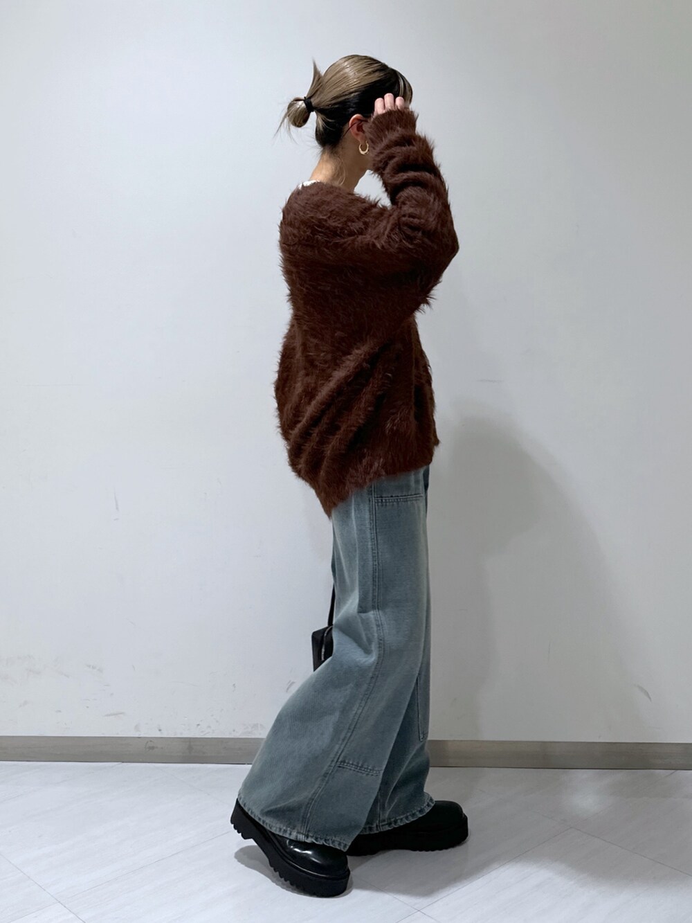 ブラウン系のカーディガン/ボレロ、ホワイト系のTシャツ/カットソー、ブルー系のデニムパンツを着用したレディースの冬コーディネートの2枚目の写真