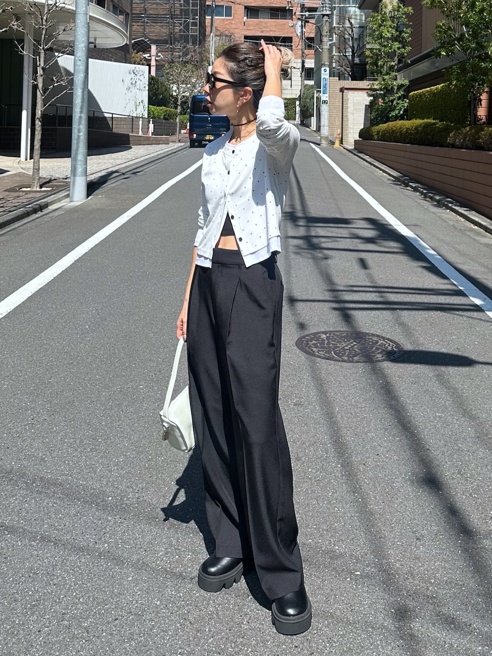 ホワイト系のTシャツ/カットソー、ブラック系のスラックス、ホワイト系のハンドバッグを着用したレディースの春コーディネートの7枚目の写真