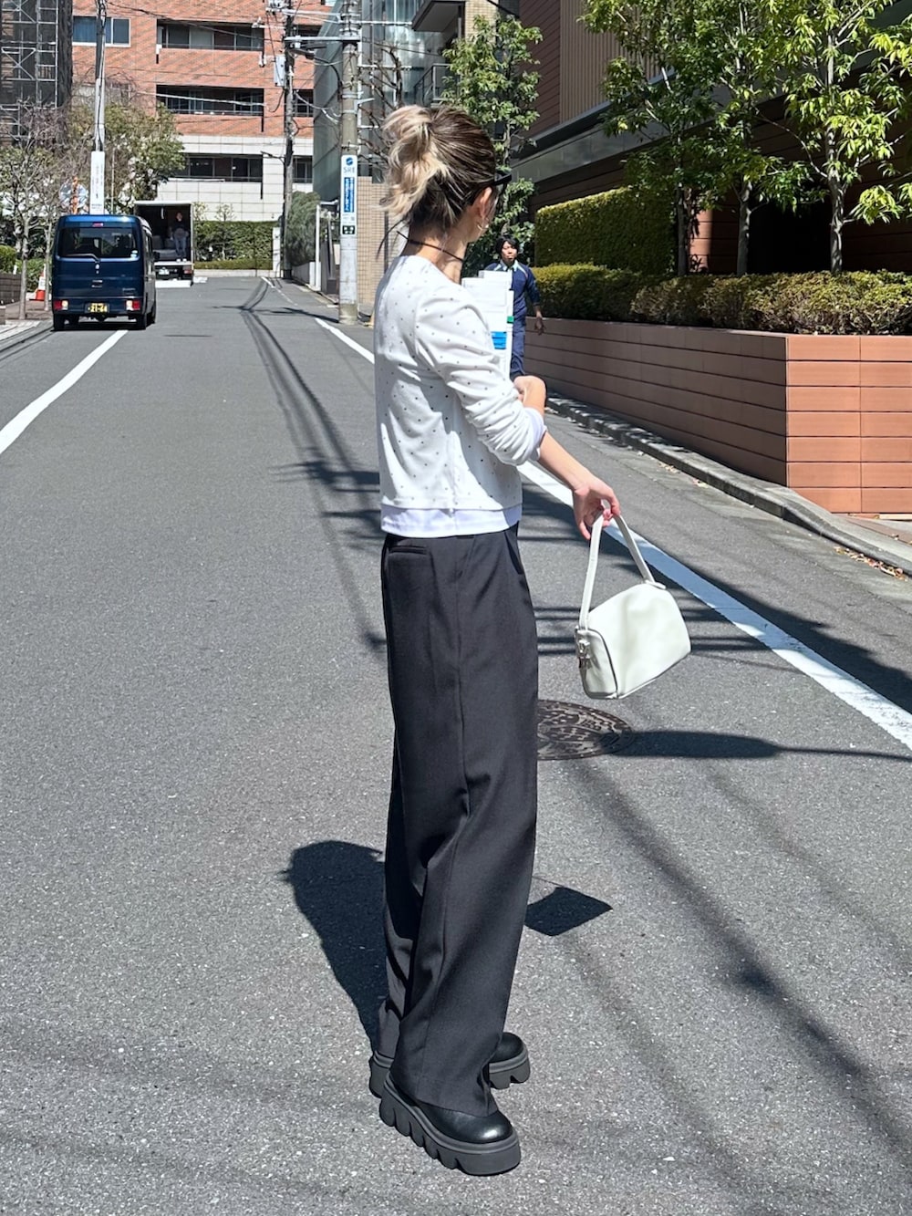 ホワイト系のTシャツ/カットソー、ブラック系のスラックス、ホワイト系のハンドバッグを着用したレディースの春コーディネートの2枚目の写真