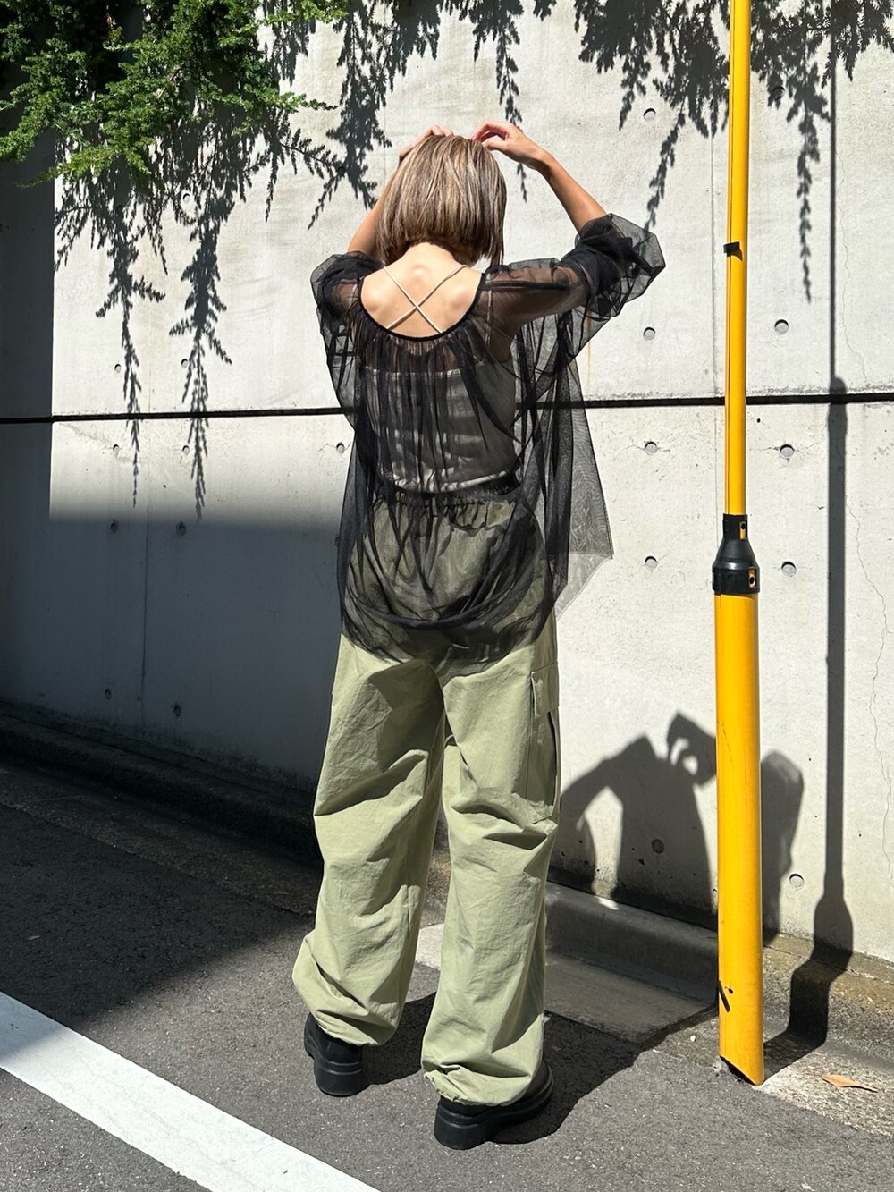 ブラック系のシャツ/ブラウス、グリーン系のカーゴパンツを着用したレディースの夏コーディネートの3枚目の写真