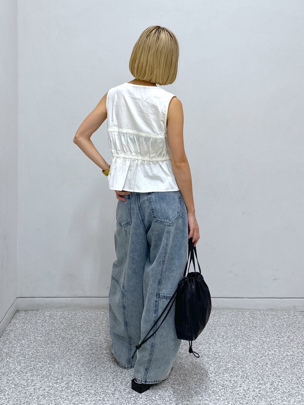 ホワイト系のシャツ/ブラウス、ブルー系のデニムパンツ、ブラック系のハンドバッグを着用したレディースの夏コーディネートの3枚目の写真