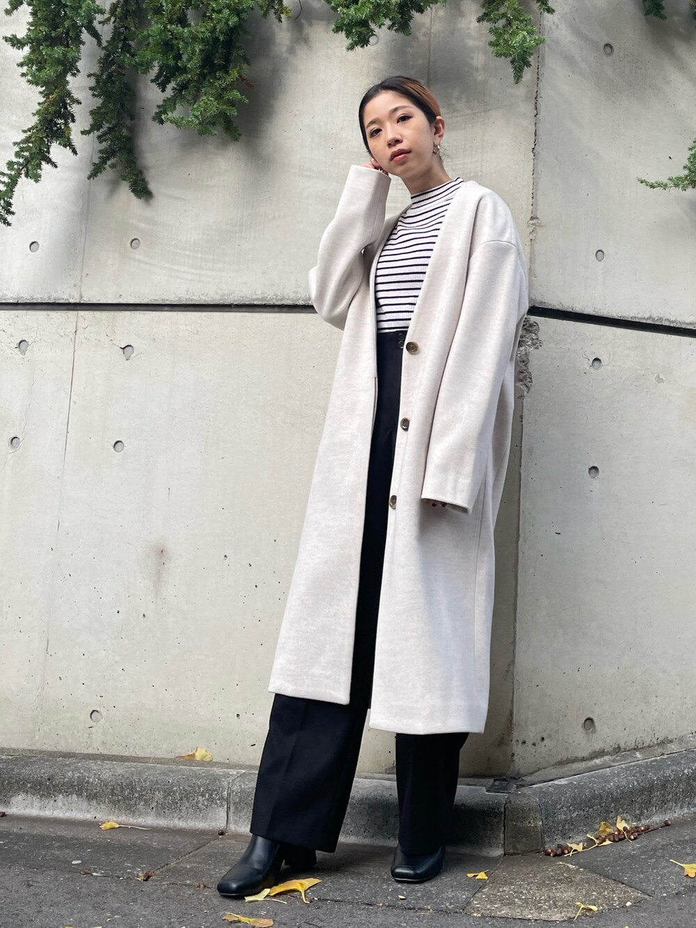 ブラック系のその他パンツ、ブラック系のブーツ、ベージュ系のノーカラーコートを着用したレディースの秋コーディネートの2枚目の写真