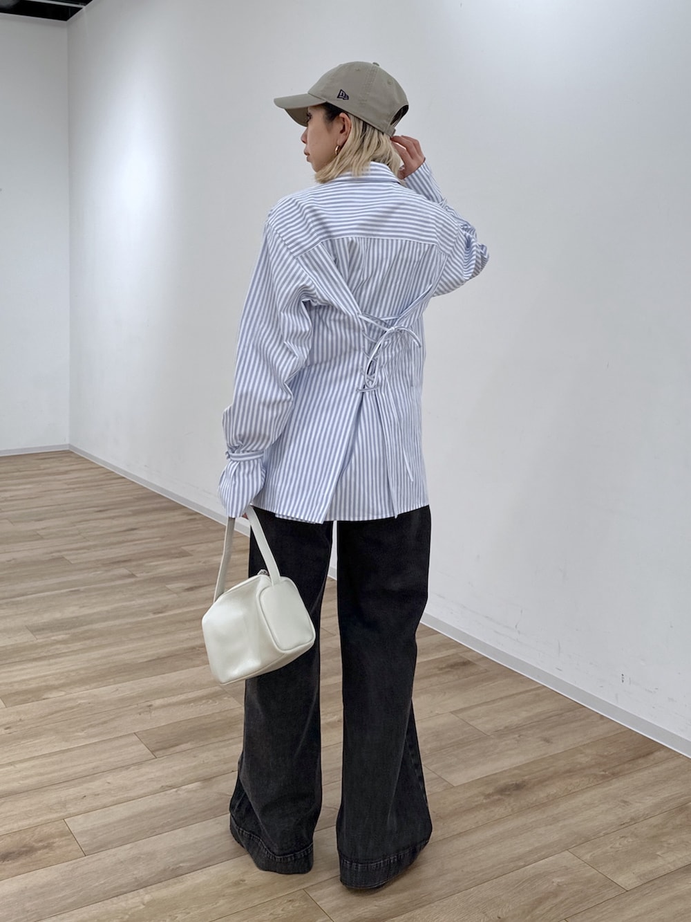 ブルー系のシャツ/ブラウス、ブラック系のデニムパンツ、ホワイト系のハンドバッグを着用したレディースの冬コーディネートの8枚目の写真