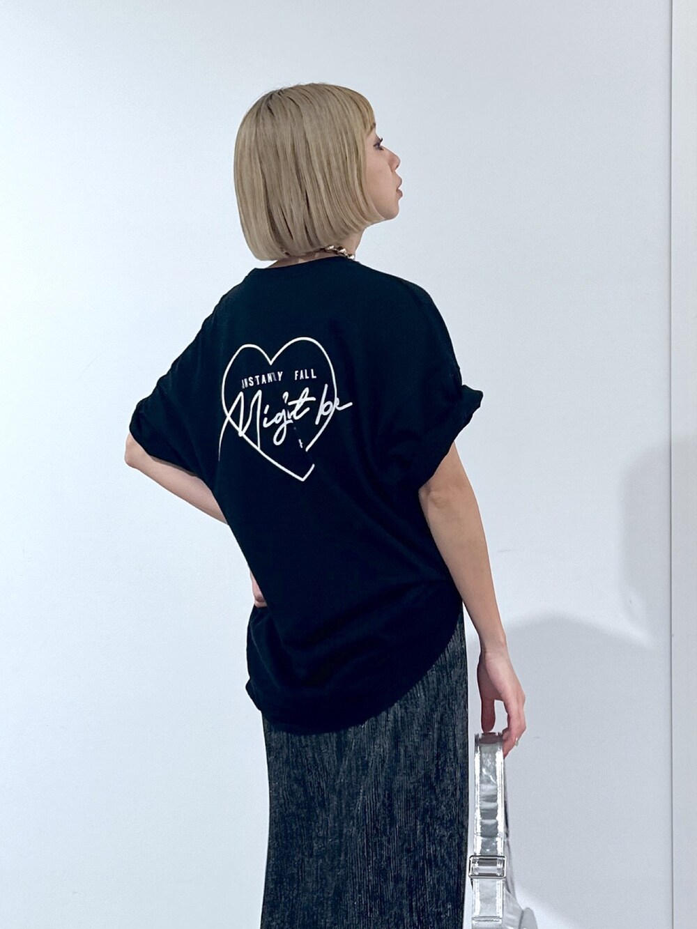 ブラック系のTシャツ/カットソー、ブラック系のスカート、シルバー系のショルダーバッグを着用したレディースの春コーディネートの5枚目の写真