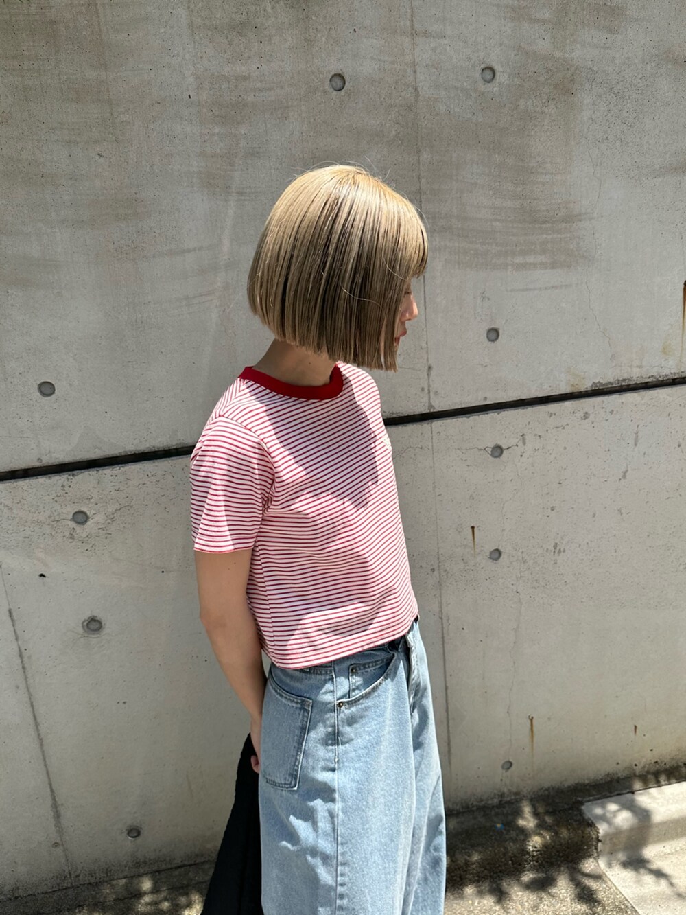 ブルー系のデニムパンツ、ブラック系のサンダル、ブラック系のショルダーバッグを着用したレディースの春コーディネートの4枚目の写真