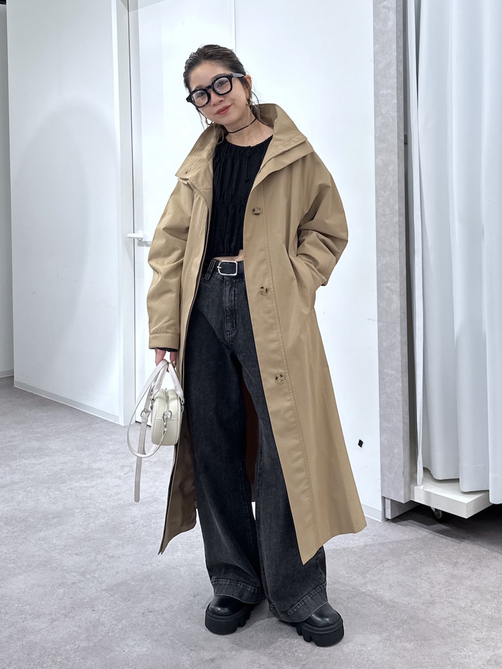 ブラック系のデニムパンツ、ブラック系のシャツ/ブラウス、ベージュ系のトレンチコートを着用したレディースの春コーディネートの7枚目の写真