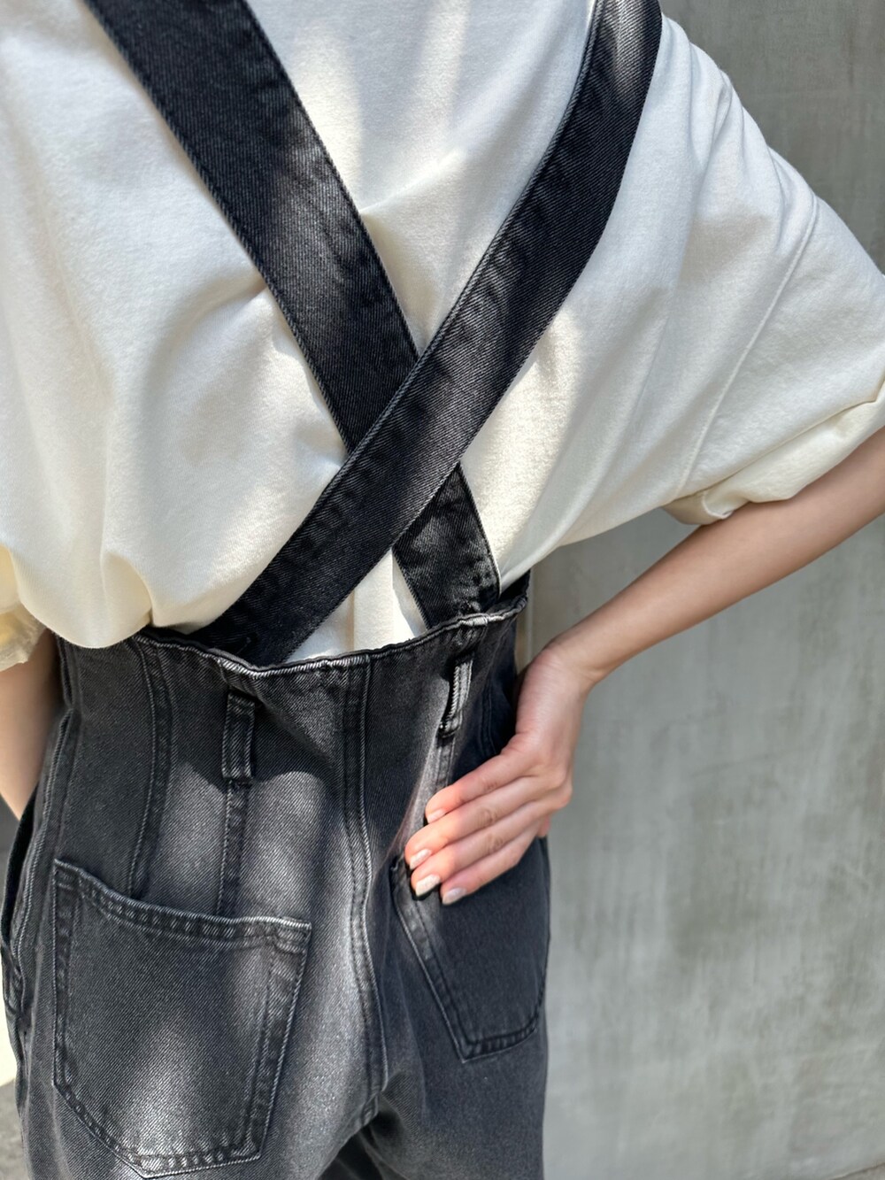 ブラック系のデニムパンツ、グリーン系のトートバッグ、ブラック系のサンダルを着用したレディースの春コーディネートの5枚目の写真