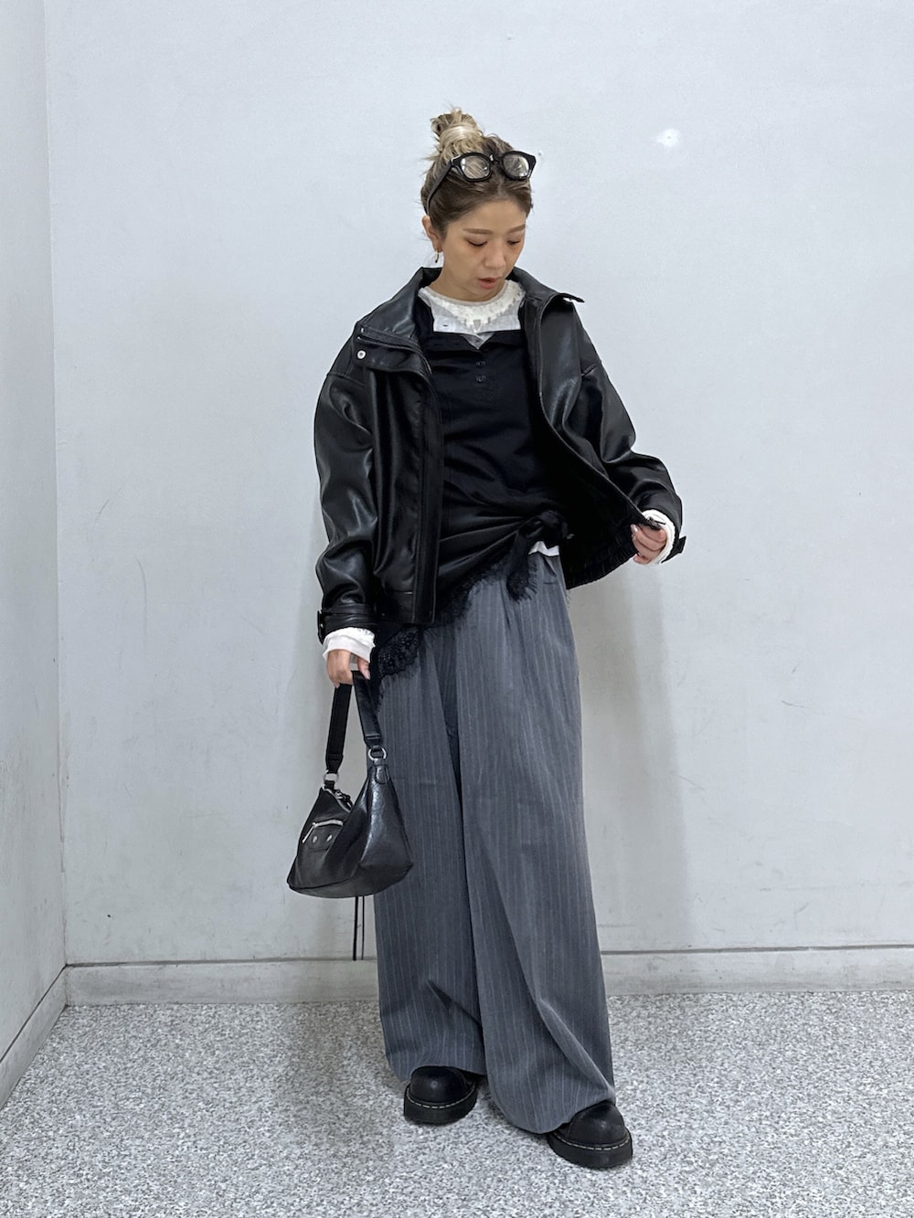 ブラック系のブルゾン、グレー系のスラックス、ブラック系のショルダーバッグを着用したレディースの秋コーディネートの2枚目の写真