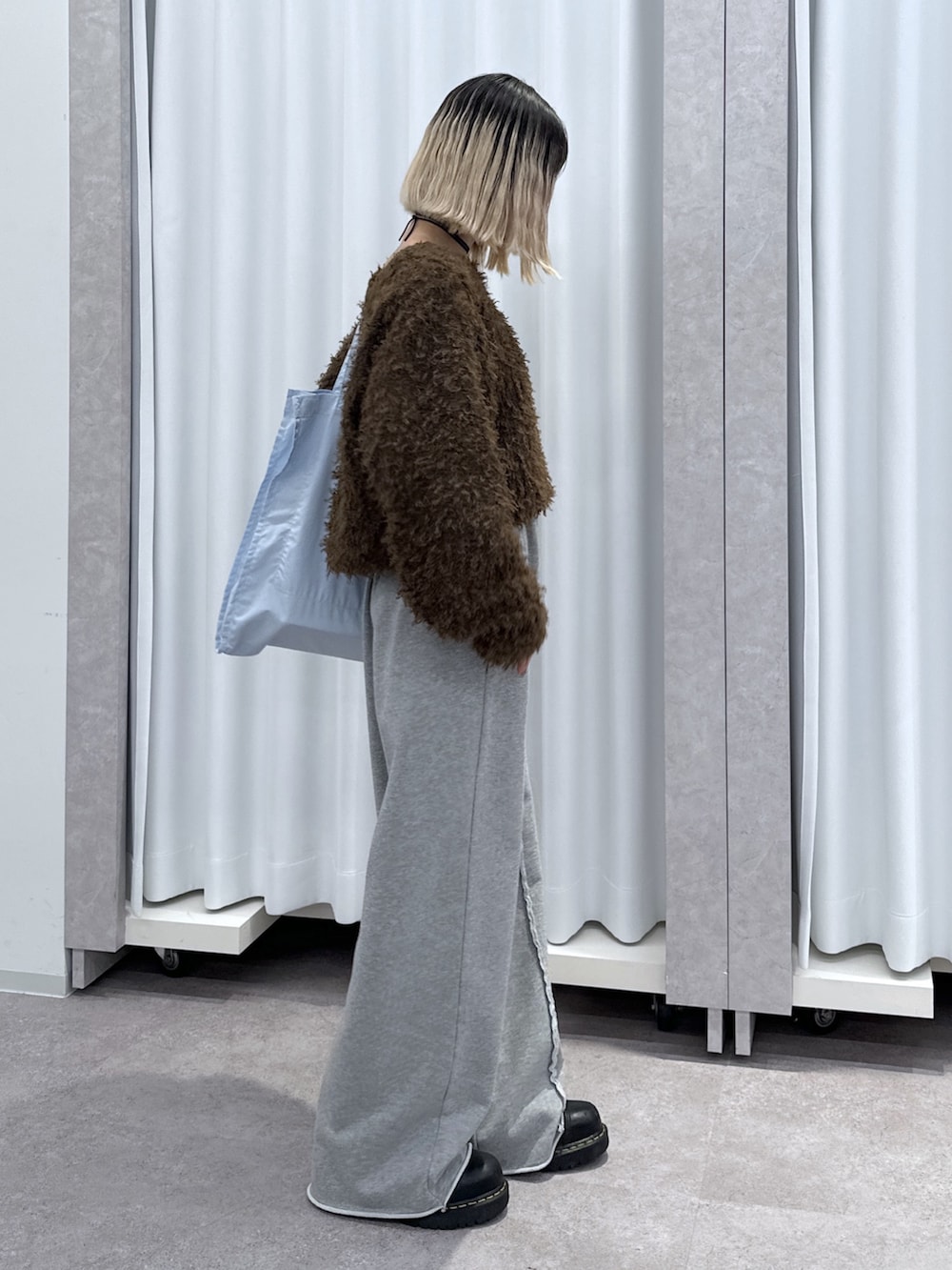 ブラウン系のTシャツ/カットソー、グレー系のその他パンツ、ブルー系のトートバッグを着用したレディースの冬コーディネートの2枚目の写真