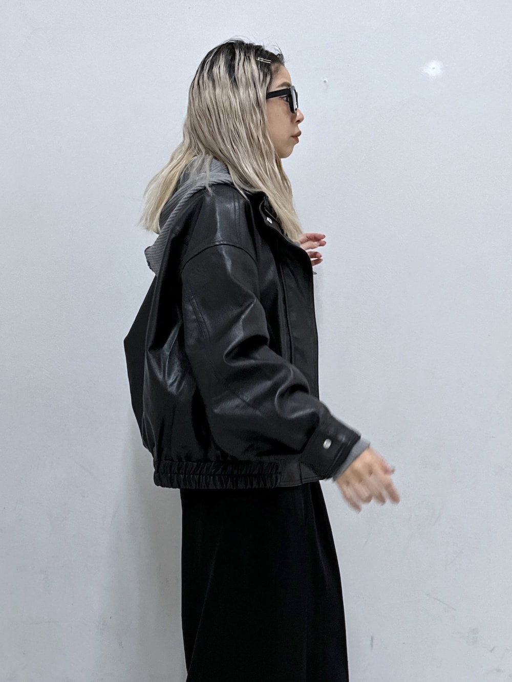 グレー系のニット/セーター、ブラック系のブルゾン、ブラック系のその他パンツを着用したレディースの秋コーディネートの5枚目の写真