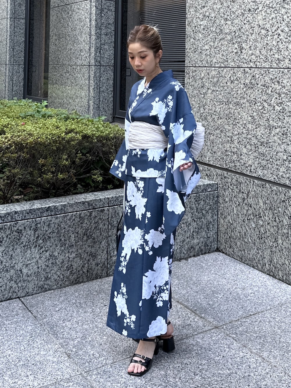 ブラック系のハンドバッグ、ブラック系のサンダル、ブルー系の浴衣を着用したレディースの夏コーディネートの2枚目の写真