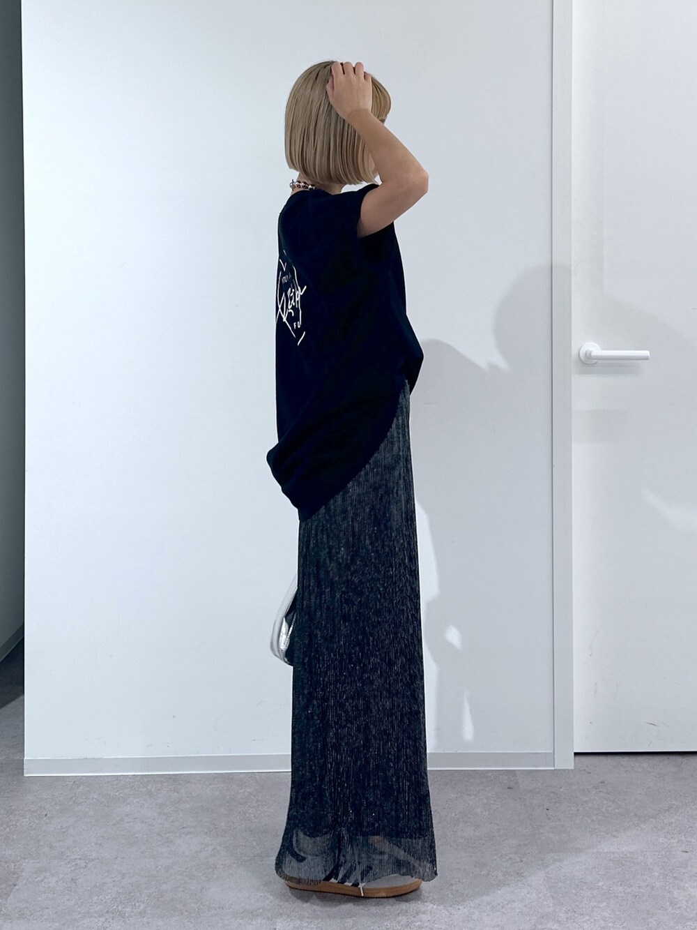 ブラック系のTシャツ/カットソー、ブラック系のスカート、シルバー系のショルダーバッグを着用したレディースの春コーディネートの2枚目の写真