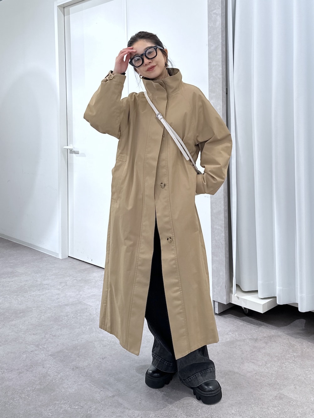 ブラック系のデニムパンツ、ブラック系のシャツ/ブラウス、ベージュ系のトレンチコートを着用したレディースの春コーディネートの8枚目の写真