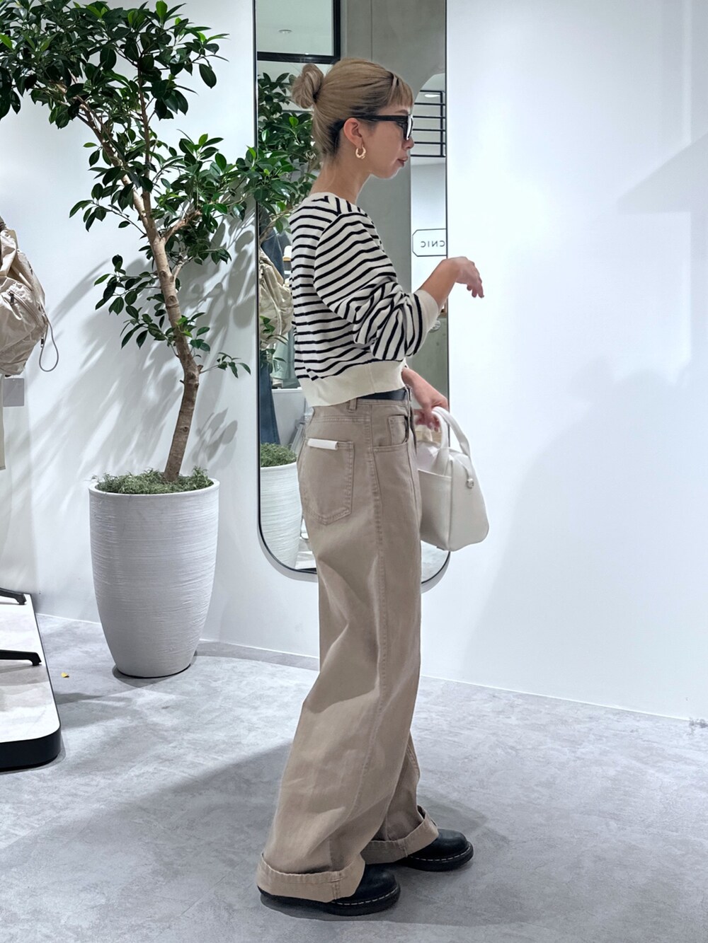 ホワイト系のカーディガン/ボレロ、ベージュ系のその他パンツ、ホワイト系のトートバッグを着用したレディースの春コーディネートの5枚目の写真