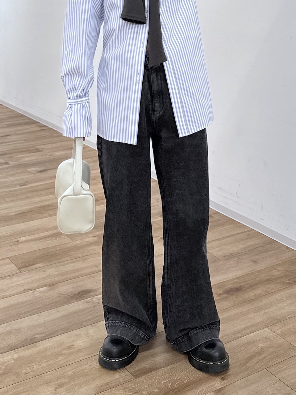 ブルー系のシャツ/ブラウス、ブラック系のデニムパンツ、ホワイト系のハンドバッグを着用したレディースの冬コーディネートの6枚目の写真