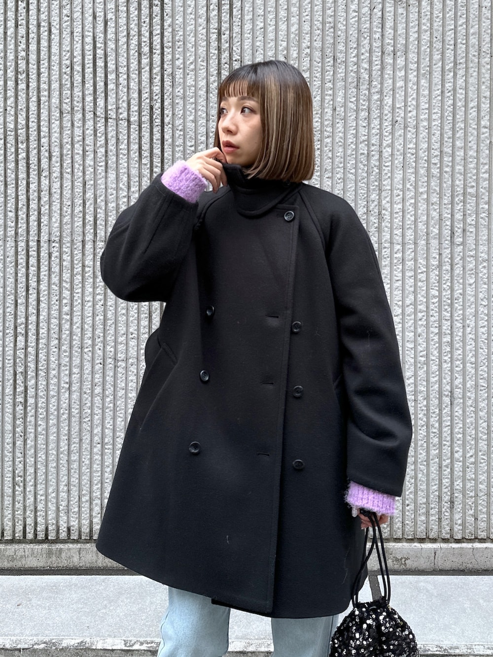 ブルー系のデニムパンツ、ブラック系のステンカラーコートを着用したレディースの冬コーディネートの6枚目の写真