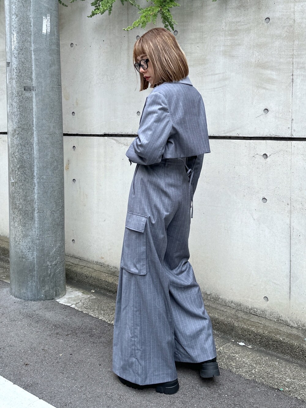 グレー系のスラックス、グレー系のテーラードジャケット、ブラック系のニット/セーターを着用したレディースの秋コーディネートの3枚目の写真