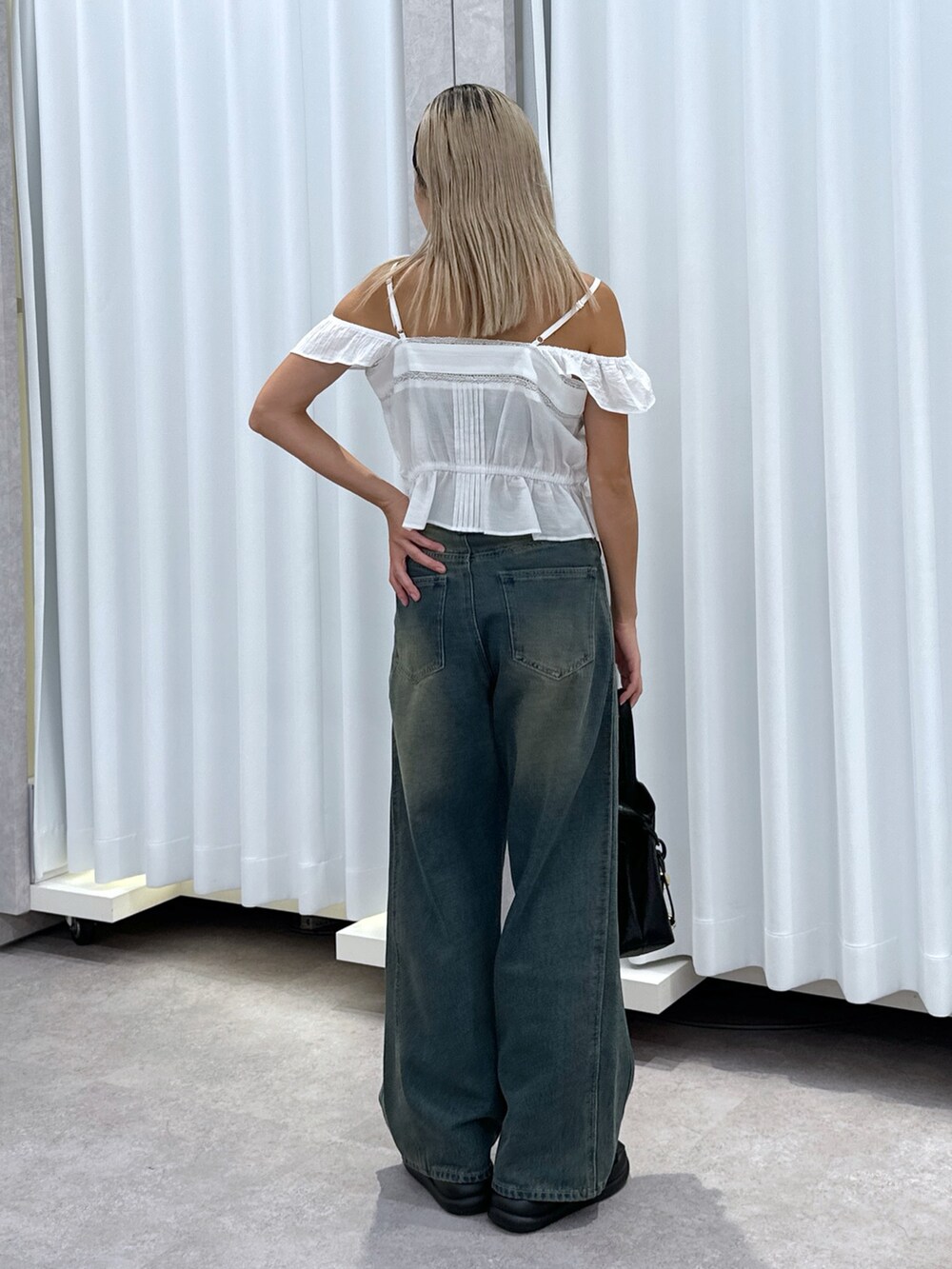 ホワイト系のシャツ/ブラウス、ブルー系のデニムパンツ、ブラック系のショルダーバッグを着用したレディースの夏コーディネートの3枚目の写真