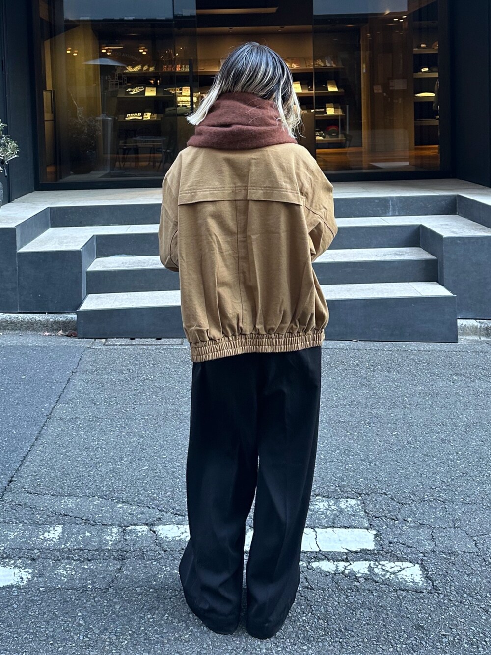 ベージュ系のブルゾン、ブラック系のスラックス、ブラウン系のストール/ショールを着用したレディースの冬コーディネートの5枚目の写真