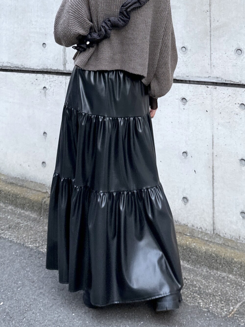 ブラック系のショルダーバッグ、ブラウン系のワンピース、ブラック系のスカートを着用したレディースの秋コーディネートの5枚目の写真