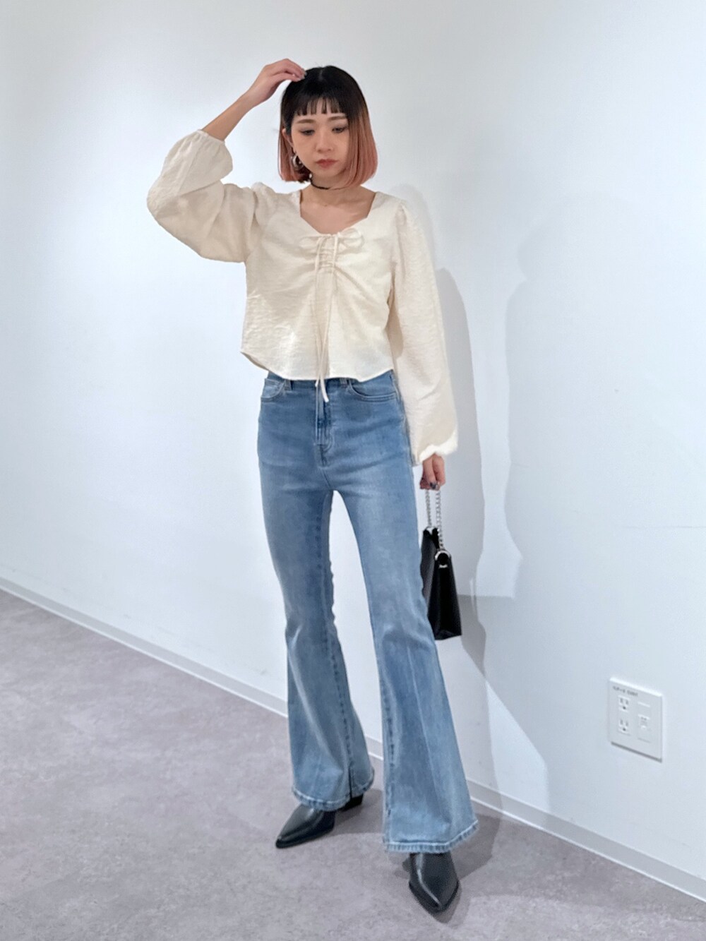 ホワイト系のシャツ/ブラウス、ブルー系のデニムパンツ、ブラック系のショルダーバッグを着用したレディースの冬コーディネートの2枚目の写真