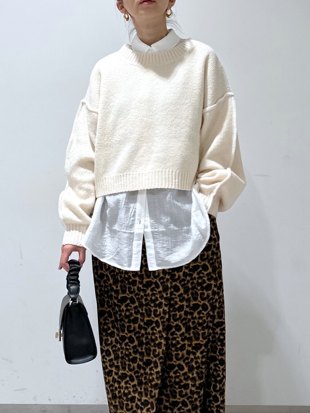 ホワイト系のニット/セーター、ホワイト系のシャツ/ブラウス、ブラウン系のスカートを着用したレディースの冬コーディネートの4枚目の写真