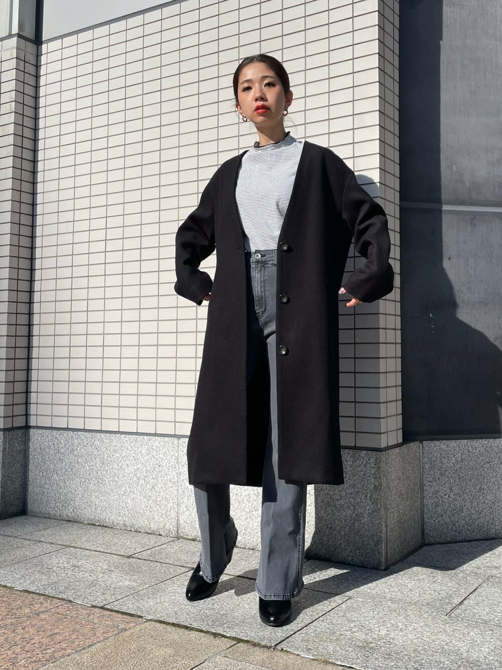 ブラック系のデニムパンツ、ブラック系のノーカラーコートを着用したレディースの夏コーディネートの2枚目の写真