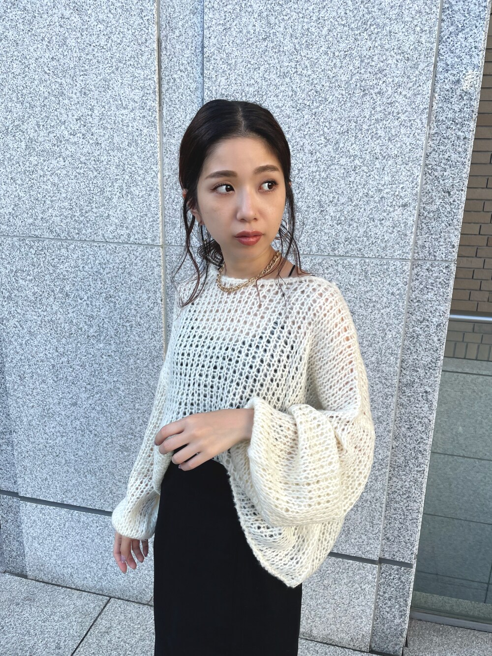 ブラック系のスカート、ホワイト系のニット/セーターを着用したレディースの秋コーディネートの3枚目の写真