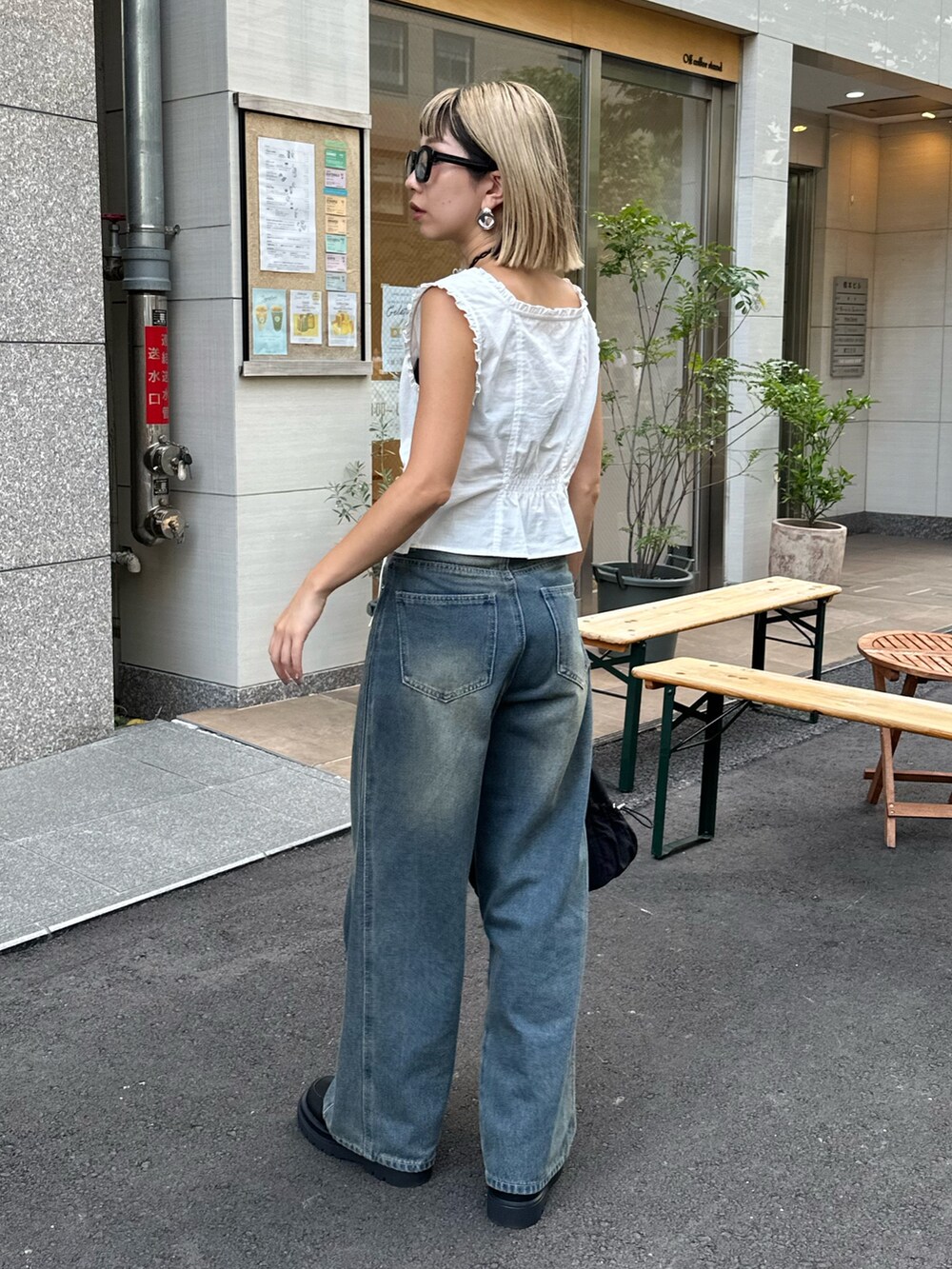 ホワイト系のシャツ/ブラウス、ブルー系のデニムパンツ、ブラック系のハンドバッグを着用したレディースの夏コーディネートの4枚目の写真