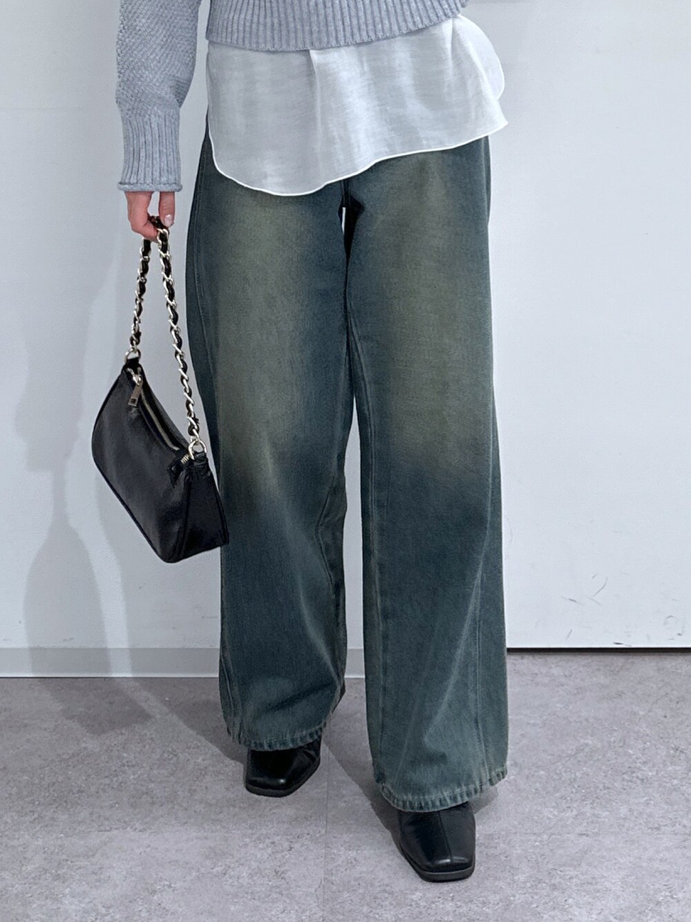 グレー系のニット/セーター、ホワイト系のTシャツ/カットソー、ブルー系のデニムパンツを着用したレディースの冬コーディネートの5枚目の写真