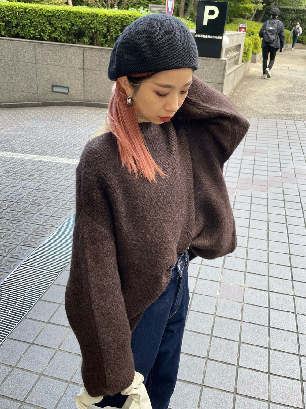 ブルー系のデニムパンツ、ブラウン系のニット/セーター、ホワイト系のブーツを着用したレディースの秋コーディネートの4枚目の写真