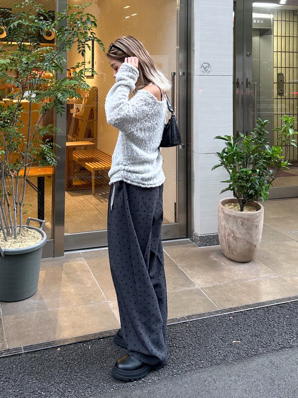 グレー系のニット/セーター、ブラック系のキャミソール、グレー系のスラックスを着用したレディースの秋コーディネートの2枚目の写真