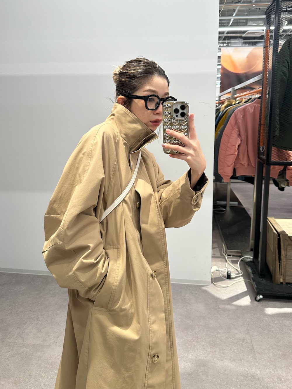 ブラック系のデニムパンツ、ブラック系のシャツ/ブラウス、ベージュ系のトレンチコートを着用したレディースの春コーディネートの5枚目の写真