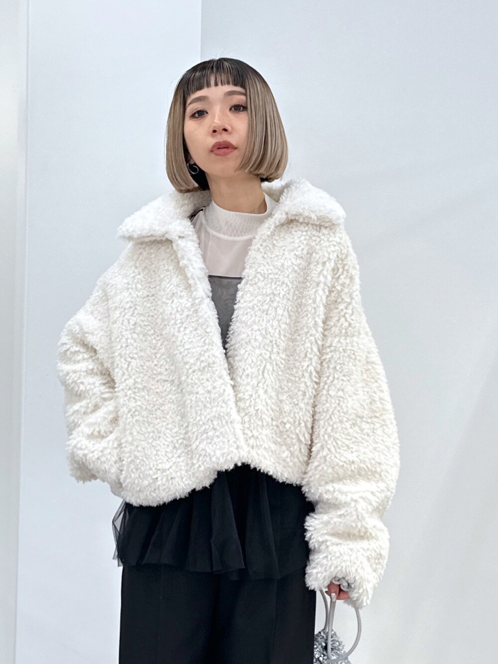 ホワイト系のブルゾン、ブラック系のシャツ/ブラウス、ホワイト系のTシャツ/カットソーを着用したレディースの冬コーディネートの2枚目の写真