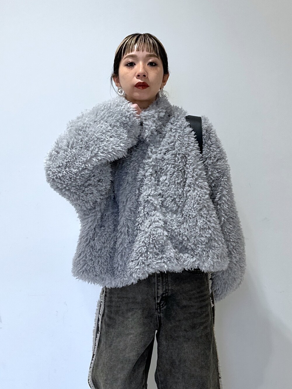 ホワイト系のスウェット、ブラック系のデニムパンツ、グレー系のブルゾンを着用したレディースの冬コーディネートの5枚目の写真