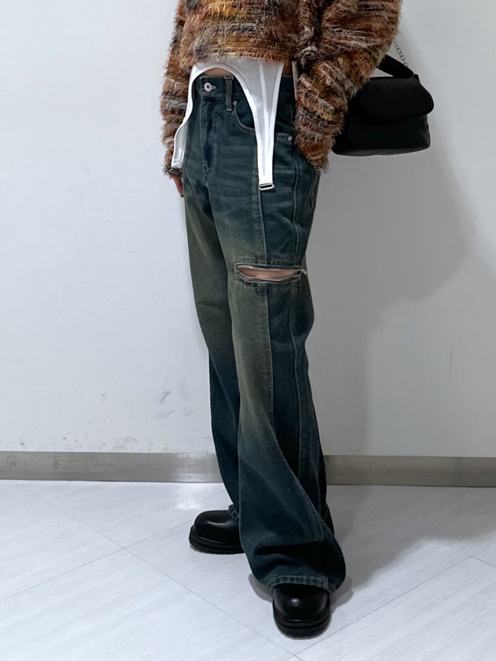 ブルー系のデニムパンツ、レッド系のニット/セーター、ブラック系のショルダーバッグを着用したレディースの秋コーディネートの5枚目の写真