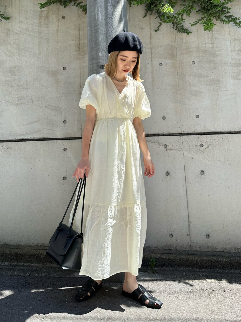 ホワイト系のワンピース、ブラック系のショルダーバッグ、ブラック系のサンダルを着用したレディースの春コーディネートの2枚目の写真