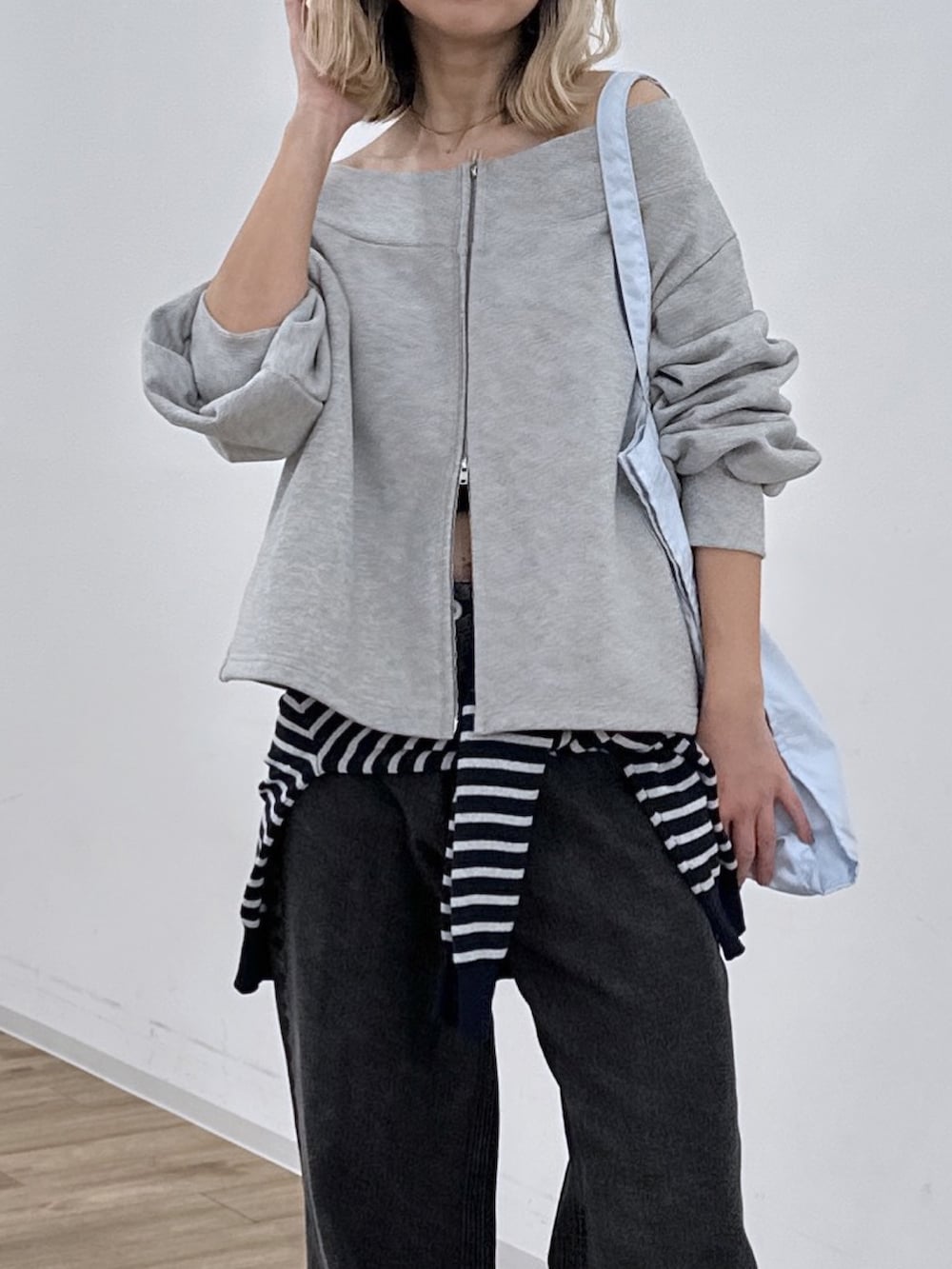 グレー系のTシャツ/カットソー、ブラック系のデニムパンツ、ブルー系のニット/セーターを着用したレディースの冬コーディネートの5枚目の写真