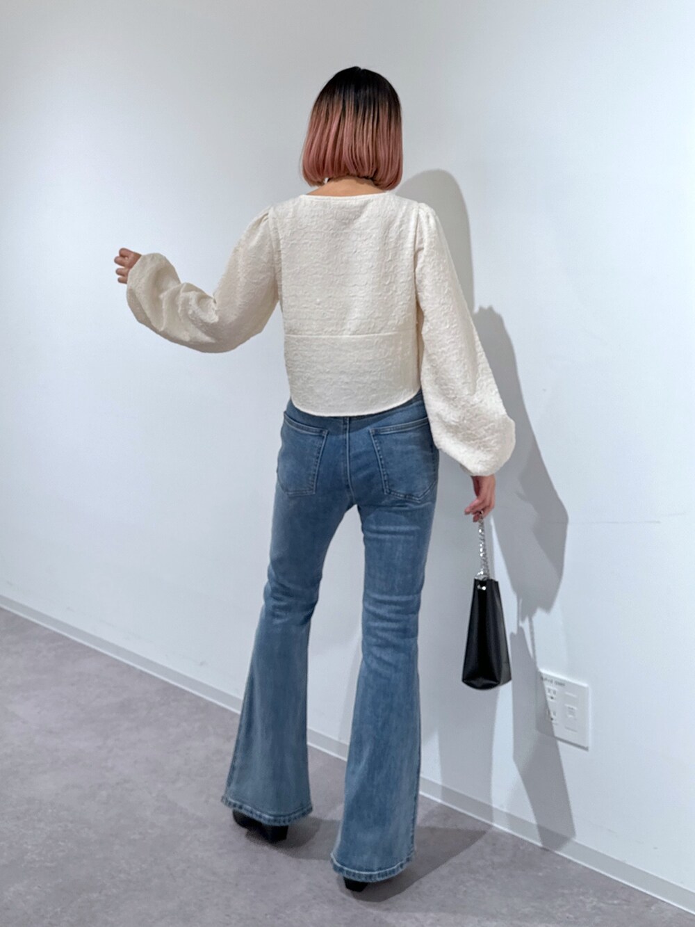 ホワイト系のシャツ/ブラウス、ブルー系のデニムパンツ、ブラック系のショルダーバッグを着用したレディースの冬コーディネートの4枚目の写真