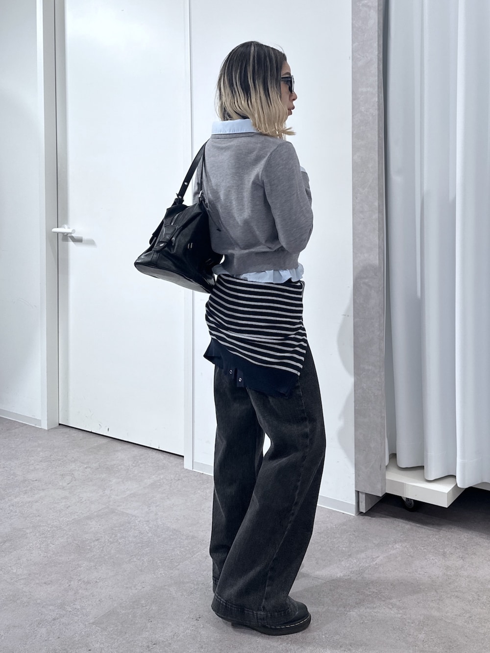 グレー系のニット/セーター、ブルー系のニット/セーター、ブラック系のデニムパンツを着用したレディースの春コーディネートの2枚目の写真