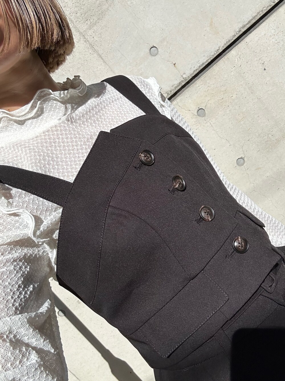 ブラック系のトートバッグ、ホワイト系のTシャツ/カットソー、ブラック系のベストを着用したレディースの秋コーディネートの4枚目の写真