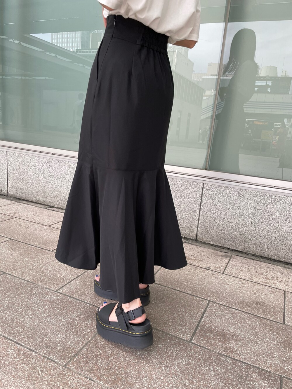 ブラック系のスカート、ホワイト系のTシャツ/カットソー、ブラック系のハットを着用したレディースの夏コーディネートの4枚目の写真