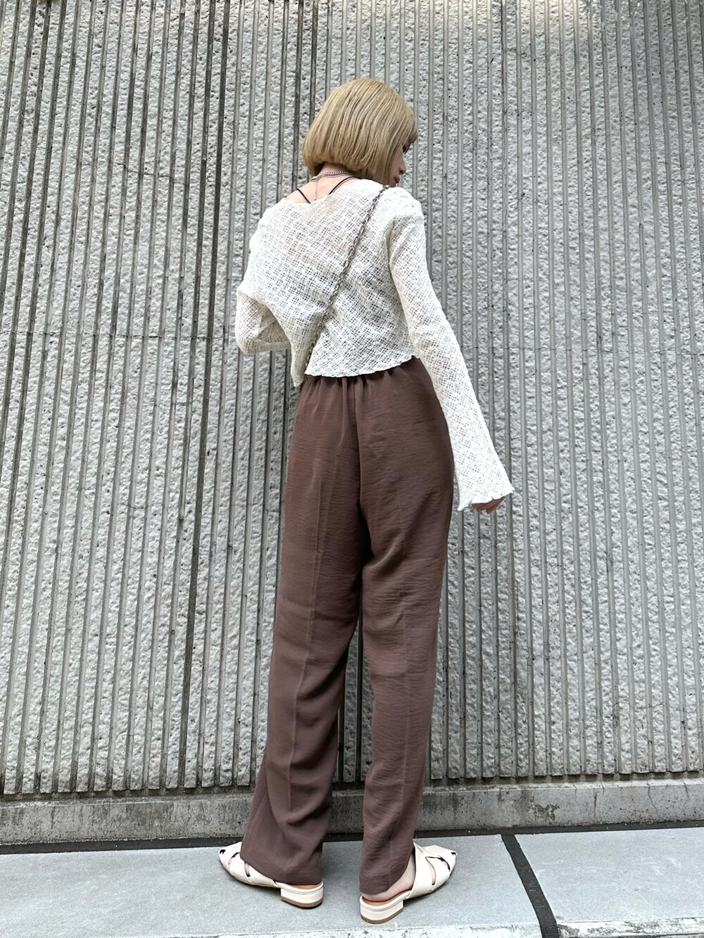 ブラウン系のその他パンツ、ホワイト系のカーディガン/ボレロ、ブラック系のトートバッグを着用したレディースの春コーディネートの2枚目の写真