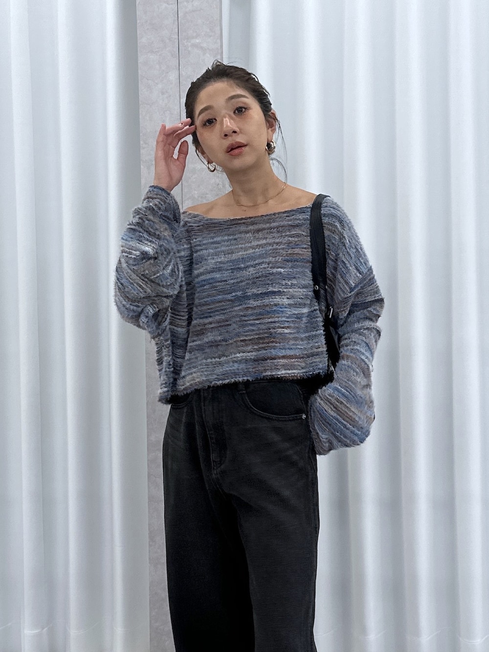 ブルー系のニット/セーター、ブラック系のデニムパンツ、ブラック系のショルダーバッグを着用したレディースの夏コーディネートの4枚目の写真