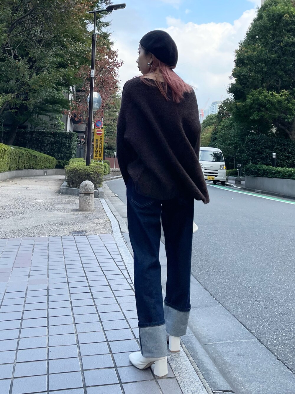 ブルー系のデニムパンツ、ブラウン系のニット/セーター、ホワイト系のブーツを着用したレディースの秋コーディネートの3枚目の写真