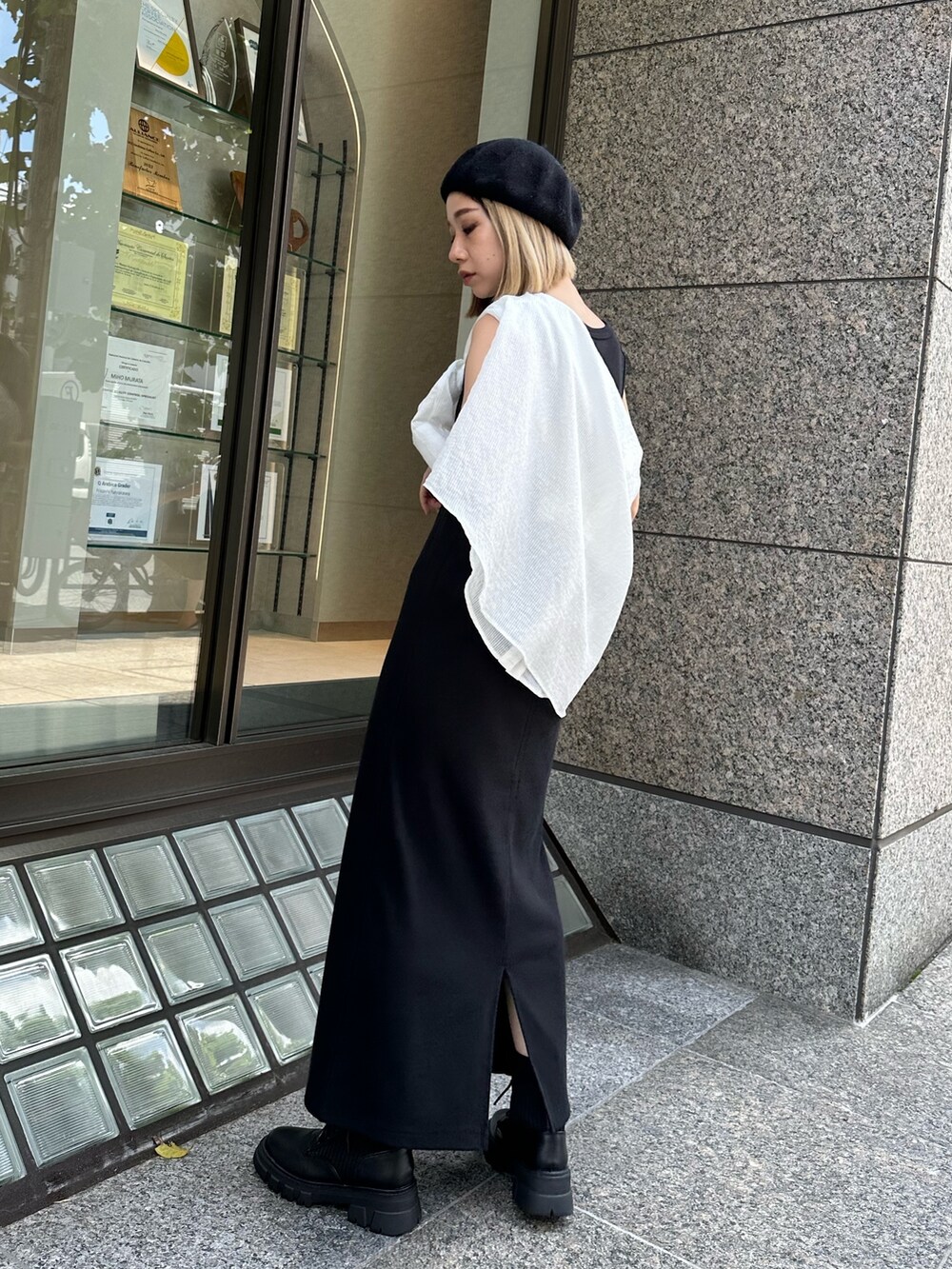 ブラック系のワンピース、ホワイト系のシャツ/ブラウス、ブラック系のブーツを着用したレディースの夏コーディネートの3枚目の写真