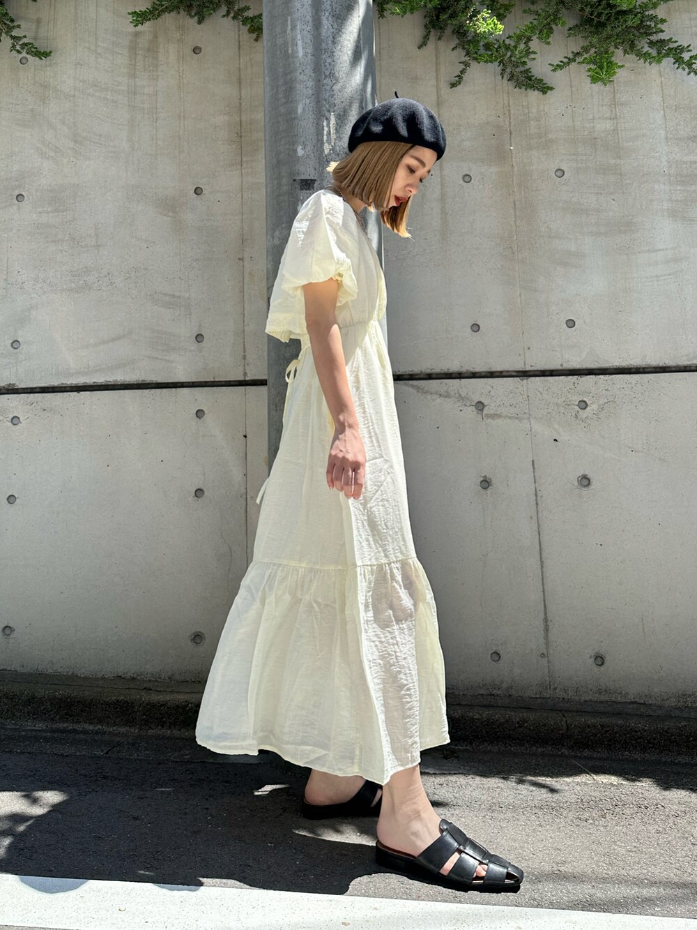 ホワイト系のワンピース、ブラック系のショルダーバッグ、ブラック系のサンダルを着用したレディースの春コーディネートの3枚目の写真